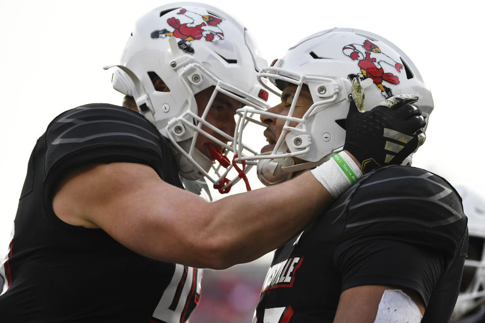 Louisville tight end Josh Lifson (42), left, congratulates running back Isaac Guerendo (23) after scoring a touchdown during the second half of an NCAA college football game against Virginia Tech in Louisville, Ky., Saturday, Nov. 4, 2023. Louisville won 34-3. (AP Photo/Timothy D. Easley)