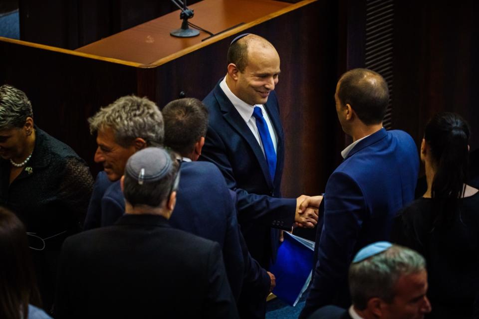 Incoming Prime Minister Naftali Bennett greets lawmakers