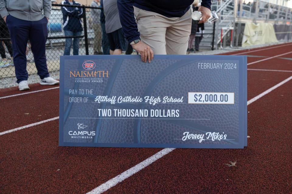 Althoff athletic director Kathy Wullerat poses with a check awarded during the presentation of the Jersey Mike’s Naismith Courage Award at Althoff High School in Belleville, Ill. on March 11, 2024.