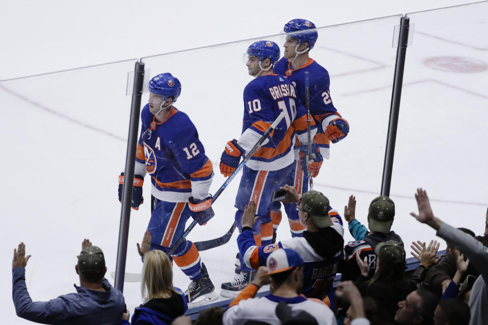 Fans cheer as New York Islanders' Josh Bailey (12), Derick Brassard (10) and Anders Lee skate past them after Brassard scored an empty-net goal during the third period of the team's NHL hockey game against the Tampa Bay Lightning on Friday, Nov. 1, 2019, in Uniondale, N.Y. The Islanders won 5-2. (AP Photo/Frank Franklin II)