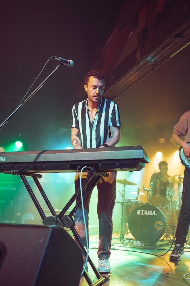 Caleb Ely performs while playing the keyboard.