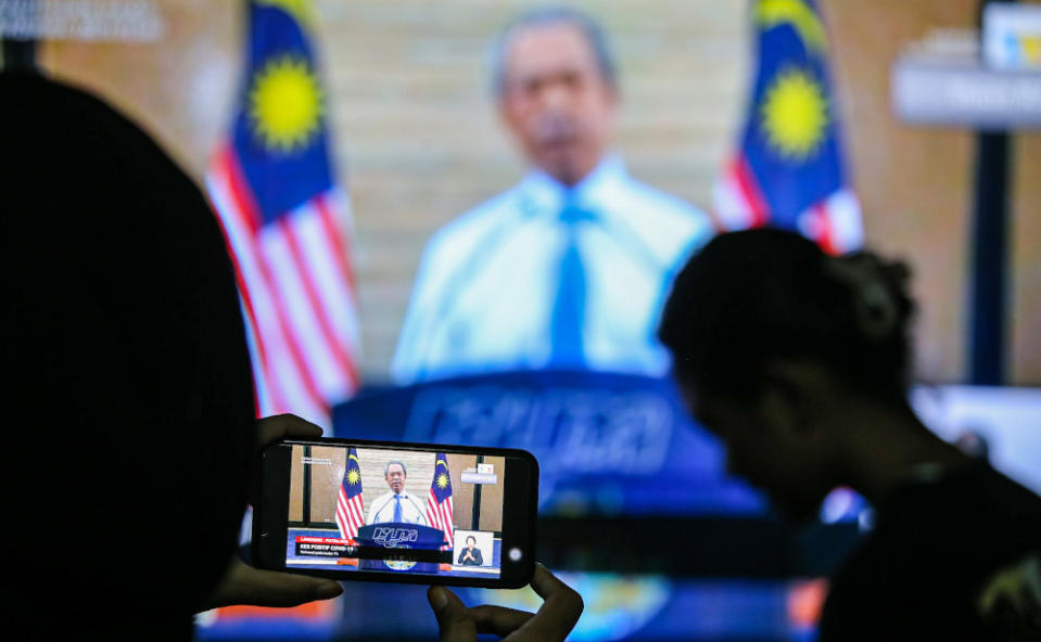 People watch the live telecast of the Prime Minister Tan Sri Muhyiddin Yassin announcing the extension of the movement control order due to the Covid-19 pandemic in Kuala Lumpur April 10, 2020. — Picture by Hari Anggara