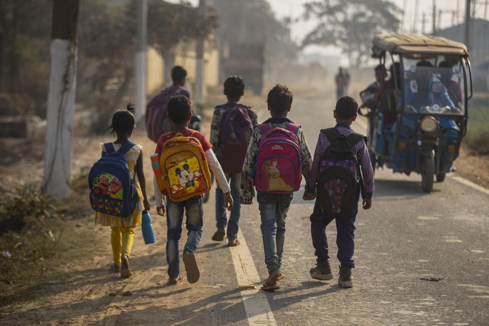 Imradul Ali, 10, right, and his friends go to a school near a landfill on the outskirts of Gauhati, India, Friday, Feb. 5, 2021. Once school is done for the day, Ali, rushes home to change out of his uniform so that he can start his job as a scavenger in India’s remote northeast. Coming from a family of scavengers or “rag pickers," Ali started doing it over a year ago to help his family make more money. Ali says he doesn’t want to spend his life doing this, but he doesn’t know what the future holds. (AP Photo/Anupam Nath)