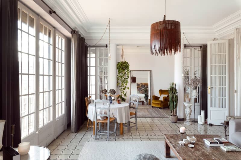 VIew of neutral toned living areas with seating and round dining table.