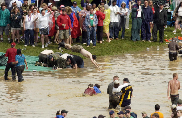 Revelers dive into a catch basin for rain water in the infield at Churchill Downs after a sudden downpour soaked the track during Kentucky Derby day festivities, Saturday, May 1, 2004, in Louisville, Ky. (AP)