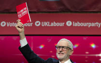 Jeremy Corbyn, Leader of Britain's opposition Labour Party, holds a copy of the manifesto on stage at the launch of Labour's General Election manifesto, at Birmingham City University, England, Thursday, Nov. 21, 2019. Britain goes to the polls on Dec. 12. (AP Photo/Kirsty Wigglesworth)