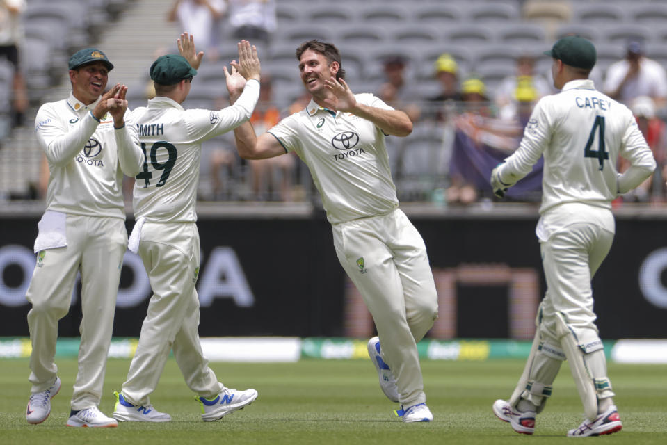 Mitchell Marsh, center, of Australia is congratulated by teammates after dismissing Babar Azam, not pictured, of Pakistan during play on the third day of the first cricket test between Australia and Pakistan in Perth, Australia, Saturday, Dec. 16, 2023. (Richard Wainwright/AAP Image via AP)