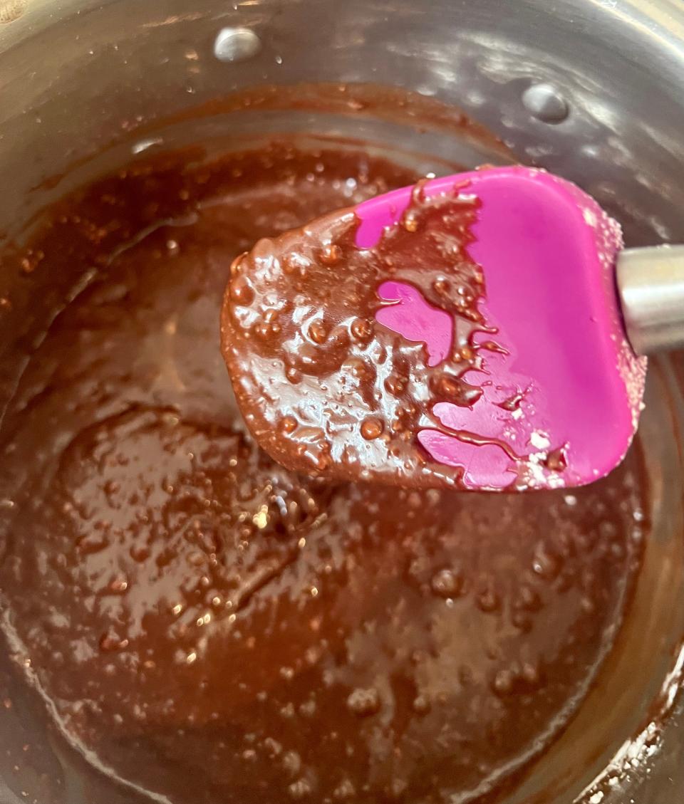 A mixing spatula coated in lumpy frosting.