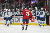 Members of the Winnipeg Jets celebrate Cole Perfetti's goal as Washington Capitals right wing Garnet Hathaway (21) looks on in the first period of an NHL hockey game, Tuesday, Jan. 18, 2022, in Washington. (AP Photo/Patrick Semansky)