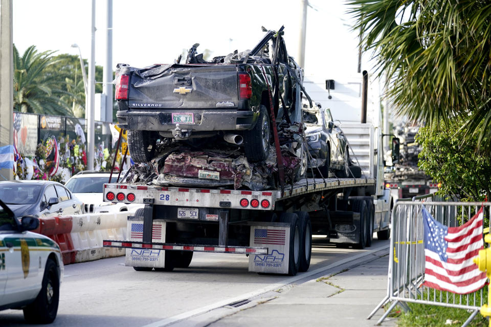 Damaged vehicles are transported from the rubble of the Champlain Towers South building, as removal and recovery work continues at the site of the partially collapsed condo building, Tuesday, July 13, 2021, in Surfside, Fla. (AP Photo/Lynne Sladky)