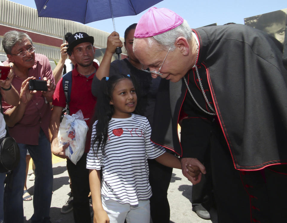 El Paso's Roman Catholic Bishop Mark Seitz escorts Celsia Palma, 9, of Honduras, and her family across a point of entry on the U.S.-Mexico border so the family could be processed into the U.S. on June 27, 2019, in Juarez, Mexico. (Photo: (AP Photo/Rudy Gutierrez))