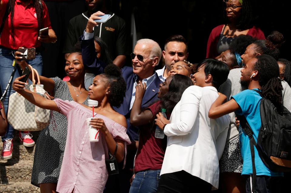 Former Vice President Joe Biden, center, takes selfies and poses for photos with students on the campus of Texas Southern University Friday, Sept. 13, 2019, in Houston.