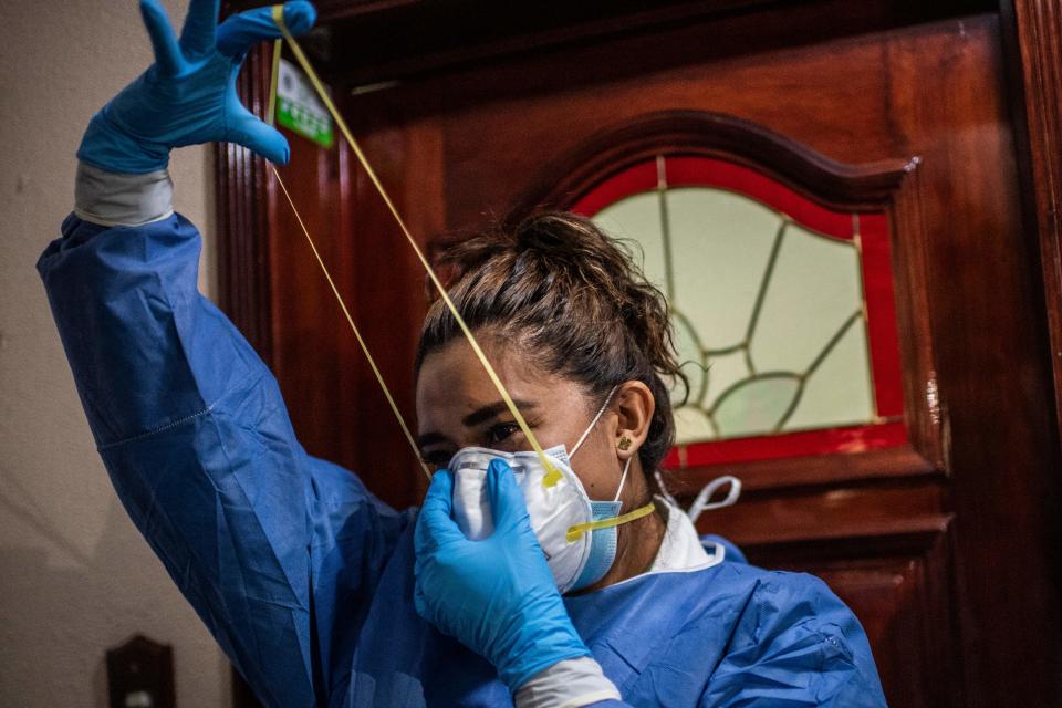 Una trabajadora de salud se prepara antes de entrar a una casa durante una visita  para llevar a cabo las pruebas COVID-19 en la Ciudad de México. Foto: Pedro Pardo / AFP vía Getty Images.