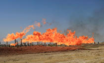 <p>Flames emerge from flare stacks at the oil fields in Kirkuk, Iraq, Oct. 18, 2017. (Photo: Alaa Al-Marjani/Reuters) </p>