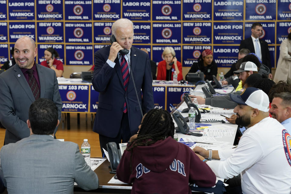 President Joe Biden speaks on the phone while visiting a phone bank at International Brotherhood of Electrical Workers Local 103, Friday, Dec. 2, 2022, in Boston. (AP Photo/Patrick Semansky)
