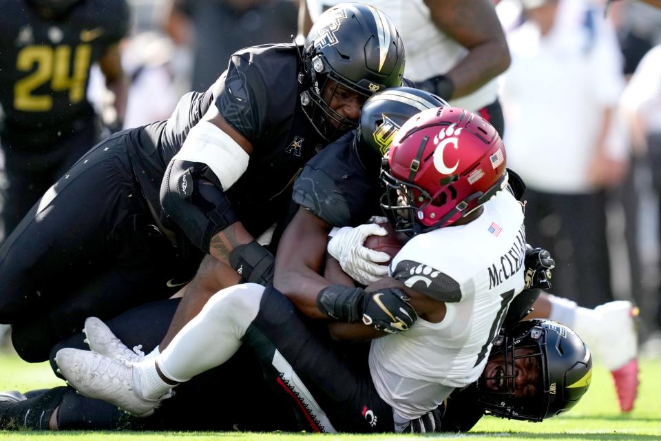 Cincinnati Bearcats running back Charles McClelland (10) is tackled for a loss by UCF Knights defensive tackle Ricky Barber (5) in the first quarter during a college football game, Saturday, Oct. 29, 2022, at FBC Mortgage Stadium in Orlando, Fla. The UCF Knights lead at halftime, 10-6.