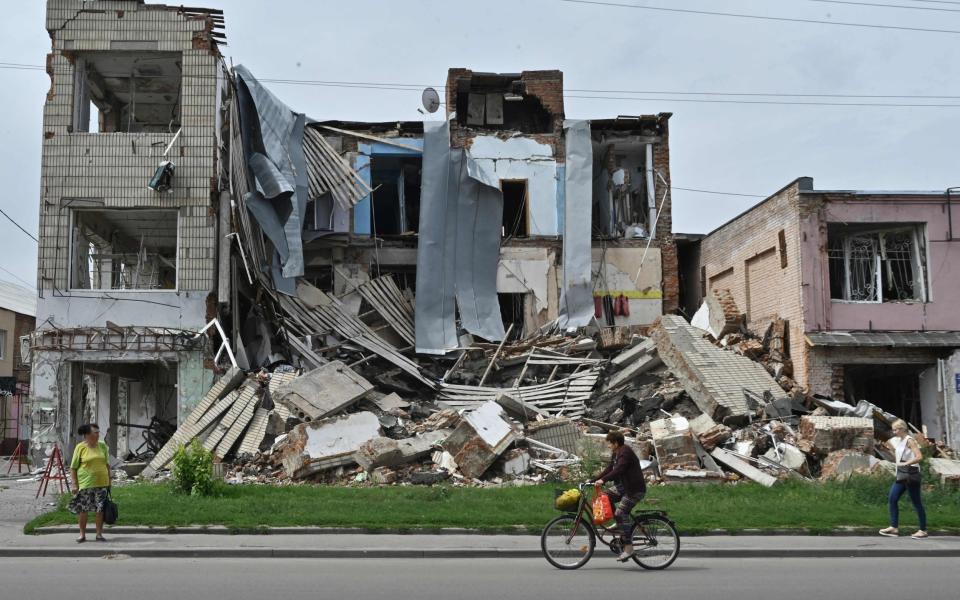 TOPSHOT - Pedestrians walk past a destroyed store in the city of Okhtyrka, Sumy region on August 1, 2022, amid the Russian invasion of Ukraine. - As towns and villages across Ukraines eastern countryside fell to the swift Russian invasion on February 24, Okhtyrka, a city of 48,000 on the Vorskla River, in Sumy region, resisted occupation. (Photo by Genya SAVILOV / AFP) (Photo by GENYA SAVILOV/AFP via Getty Images) - GENYA SAVILOV/AFP via Getty Images