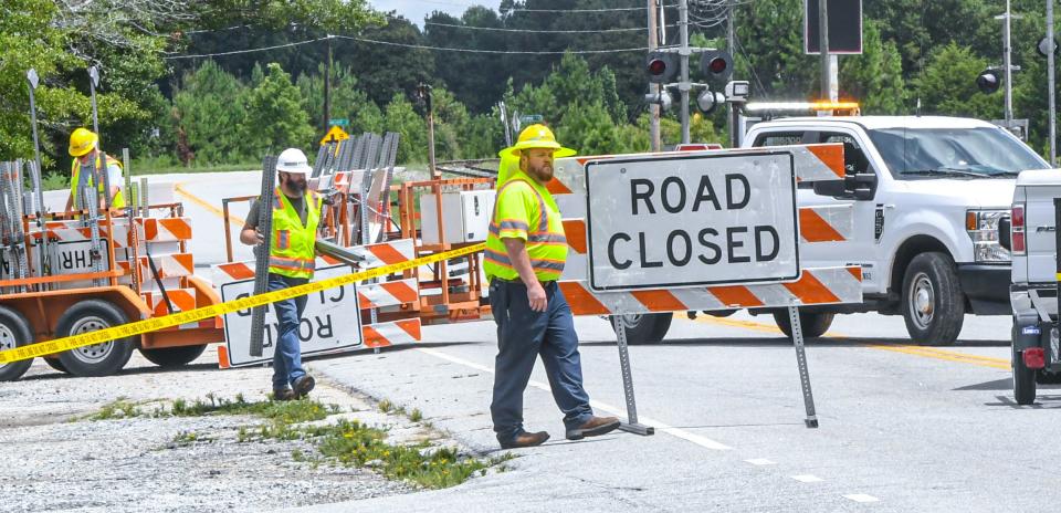 SCDOT workers place road closed signs on State Highway 20 at Blake Dairy Road in Belton, S.C. Thursday, July 25, 2024.