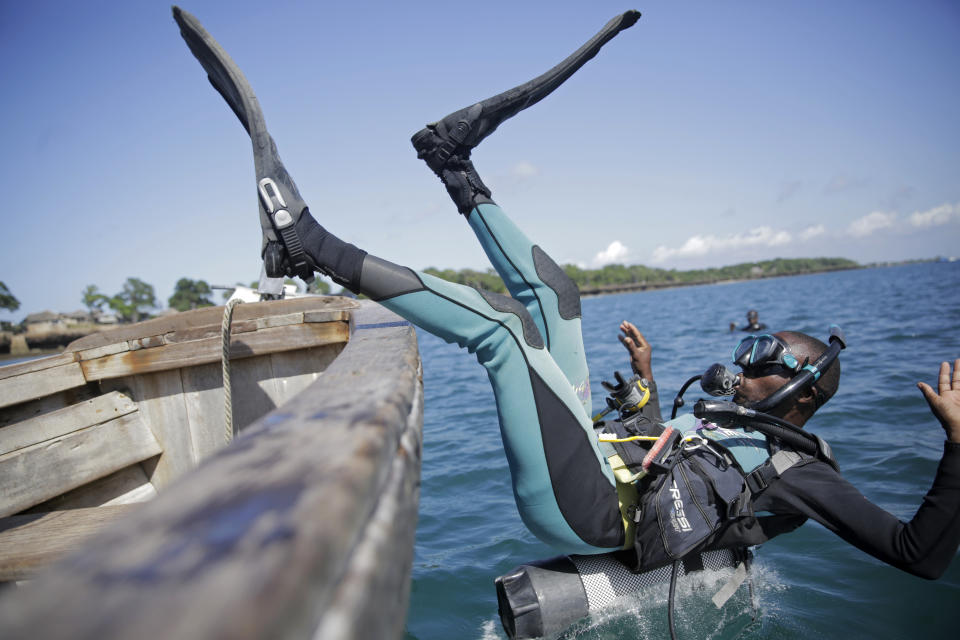 Coral reef restoration ranger Dosa Mshenga Mchambi heads into the Indian Ocean to place artificial reef structure near Shimoni, Kenya on Tuesday, June 14, 2022. The marine area off the coast of Kenya at Wasini Island, jointly managed by a foundation and the island's community, has been planting over 8,000 corals a year since early 2010s and placed about 800 artificial reef structures in the channel in a bid to restore Wasini's coral gardens. (AP Photo/Brian Inganga)