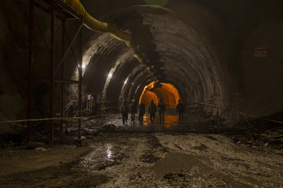 Workers employed by the Megha Engineering And Infrastructures Limited (MEIL) walk inside the Nilgrar Tunnel after the end of their shift in Baltal area northeast of Srinagar, Indian controlled Kashmir, Tuesday, Sept. 28, 2021. High in a rocky Himalayan mountain range, hundreds of people are working on an ambitious project to drill tunnels and construct bridges to connect the Kashmir Valley with Ladakh, a cold-desert region isolated half the year because of massive snowfall. The $932 million project’s last tunnel, about 14 kilometers (9 miles) long, will bypass the challenging Zojila pass and connect Sonamarg with Ladakh. Officials say it will be India’s longest and highest tunnel at 11,500 feet (3,485 meters). (AP Photo/Dar Yasin)