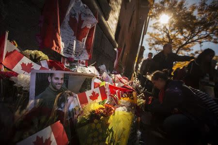 A photograph of Cpl. Nathan Cirillo is displayed at a makeshift memorial in honour of his death, as people pay their respects outside of The Lieutenant-Colonel John Weir Foote Armoury in Hamilton October 23, 2014. REUTERS/Mark Blinch