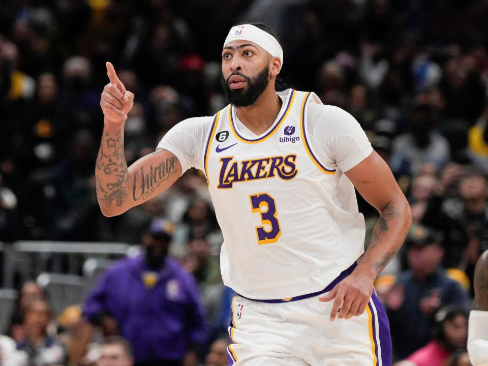 Anthony Davis points while running up the floor during a game.