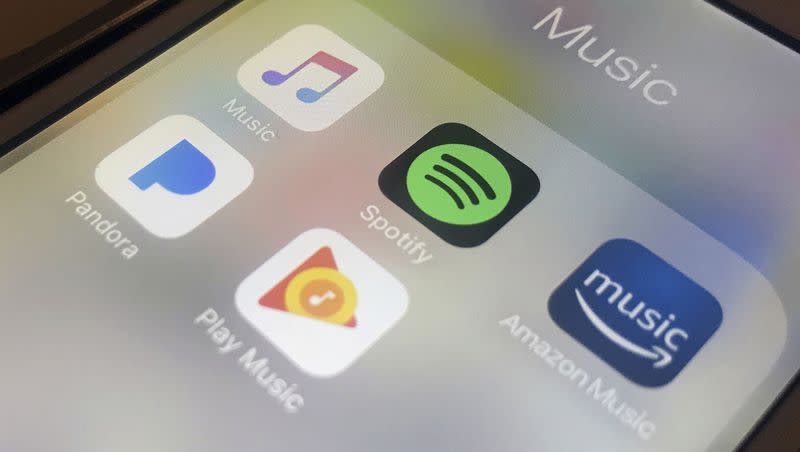 This Jan. 28, 2018, file photo shows music streaming apps clockwise from top left, Apple, Spotify, Amazon, Pandora and Google on an iPhone in New York. Spotify announced Monday that Premium plan prices will increase.