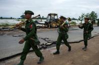 <p>Myanmar soldiers walk past a flood-damaged road in Swar town of Bago region in Myanmar on Aug. 30, 2018. (Photo: Ye Aung Thu/AFP/Getty Images) </p>