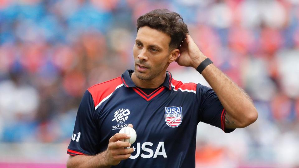 Shadley van Schalkwyk wears the blue kit of the USA and holds and white ball in his hand during a recent match at the T20 World Cup