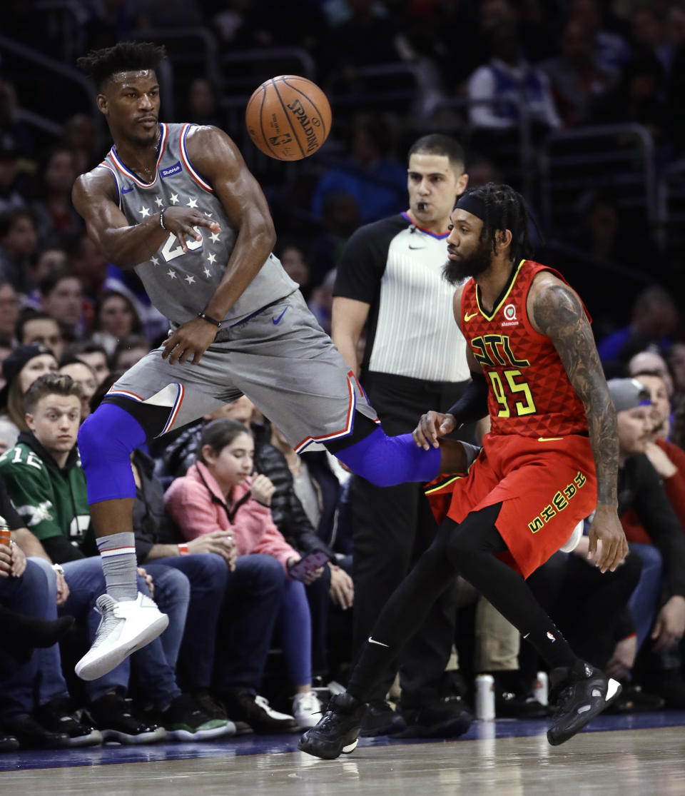 Philadelphia 76ers' Jimmy Butler, left, passes the ball as Atlanta Hawks' DeAndre' Bembry defends during the first half of an NBA basketball game Friday, Jan. 11, 2019, in Philadelphia. (AP Photo/Matt Slocum)