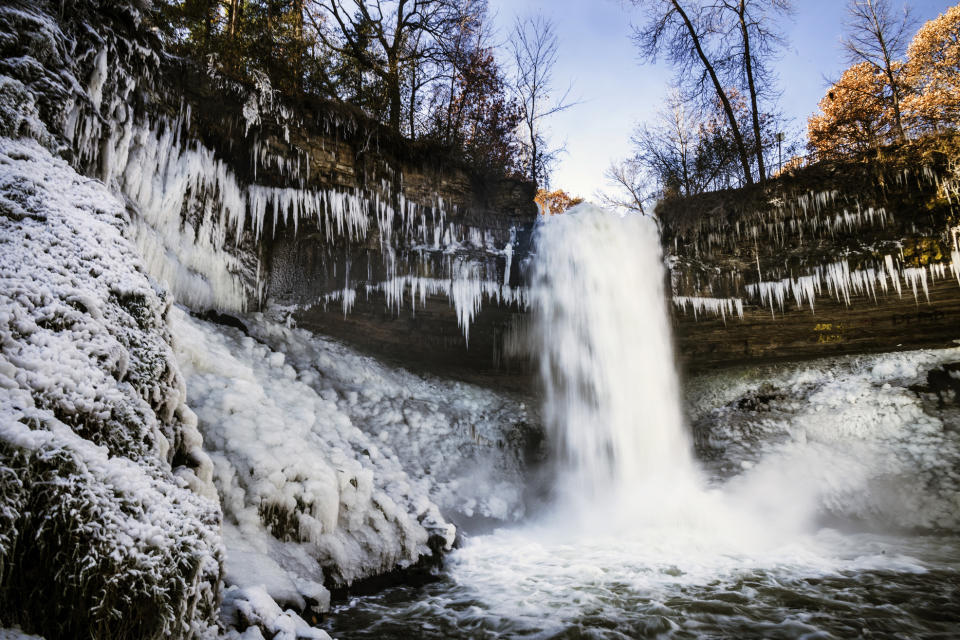 Minnehaha Falls' icy spray coats its sides with ice and snow due to low temperatures in Minneapolis, Monday, Nov. 11, 2019. (Richard Tsong-Taatarii/Star Tribune via AP)