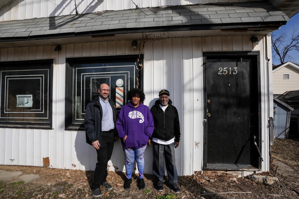 Steve Wilke-Shapiro (left) April Thomas, and Harlan Thomas stand in front of what use to be Harlan Barber Shop on Friday, March 3, 2023. Wilke-Shapiro recently bought the building at 2513 Woodland Ave. and successfully got it designated a local landmark.