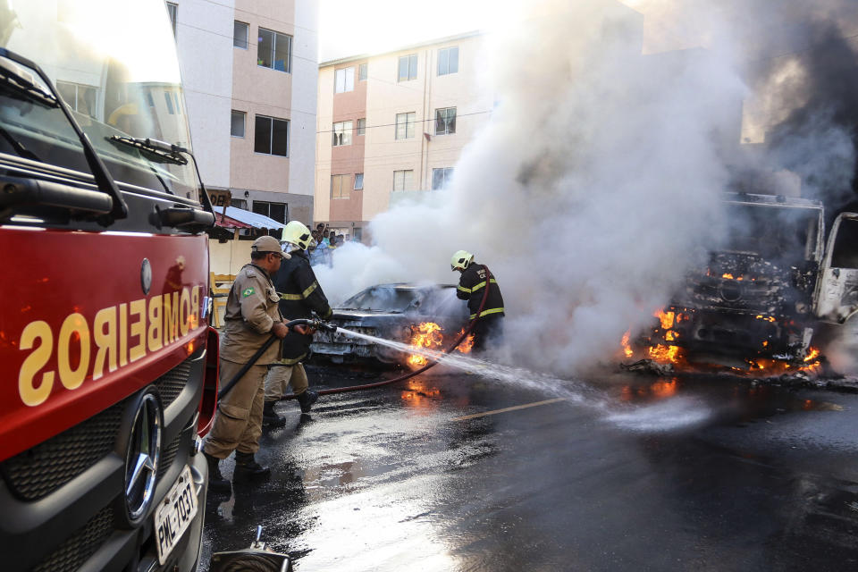 Firefighters put out torched vehicles on a street after attacks in the city of Fortaleza, northeastern Brazil, Thursday, Jan. 3, 2019. Brazil's newly inaugurated government has ordered military police sent to Ceara state following a wave of attacks on banks, public buildings and infrastructure over the past two days, which have hit 15 cities, including the capital. (AP Photo/Alex Gomes/O Povo)