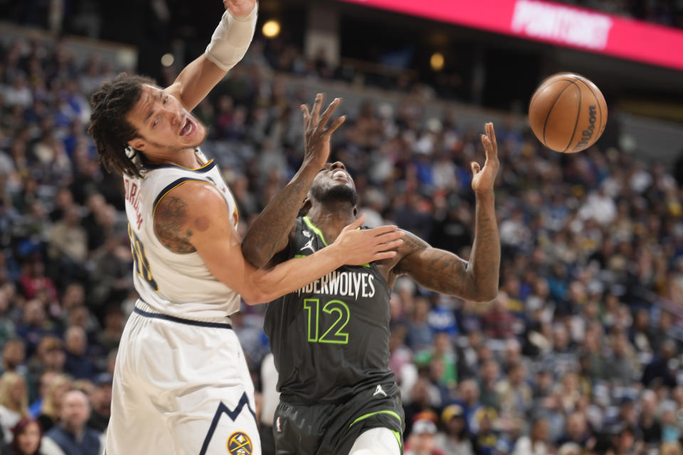 Denver Nuggets forward Aaron Gordon, left, reacts after fouling Minnesota Timberwolves forward Taurean Prince as he drives to the net in the first half of an NBA basketball game Wednesday, Jan. 18, 2023, in Denver. (AP Photo/David Zalubowski)