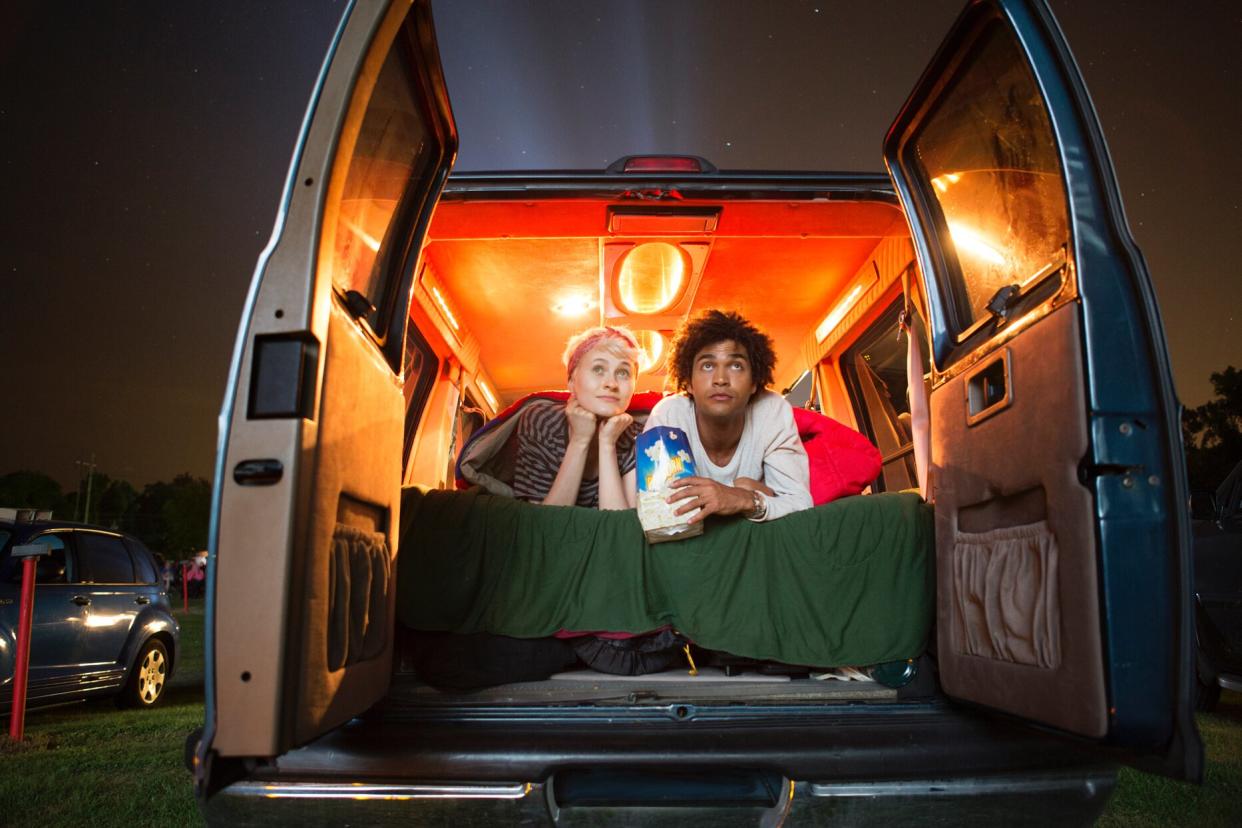 couple laying in back of van at drive in movie theater