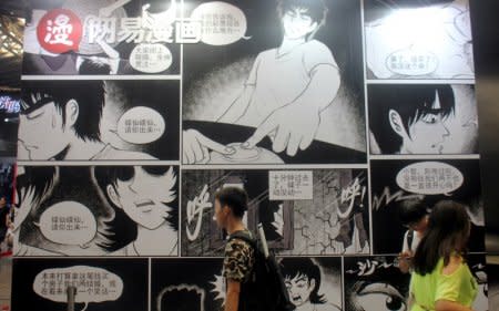 People walk past a booth of NetEase Comics at the China International Cartoon and Game (CCG) Expo in Shanghai, China July 6, 2017. REUTERS/Stringer