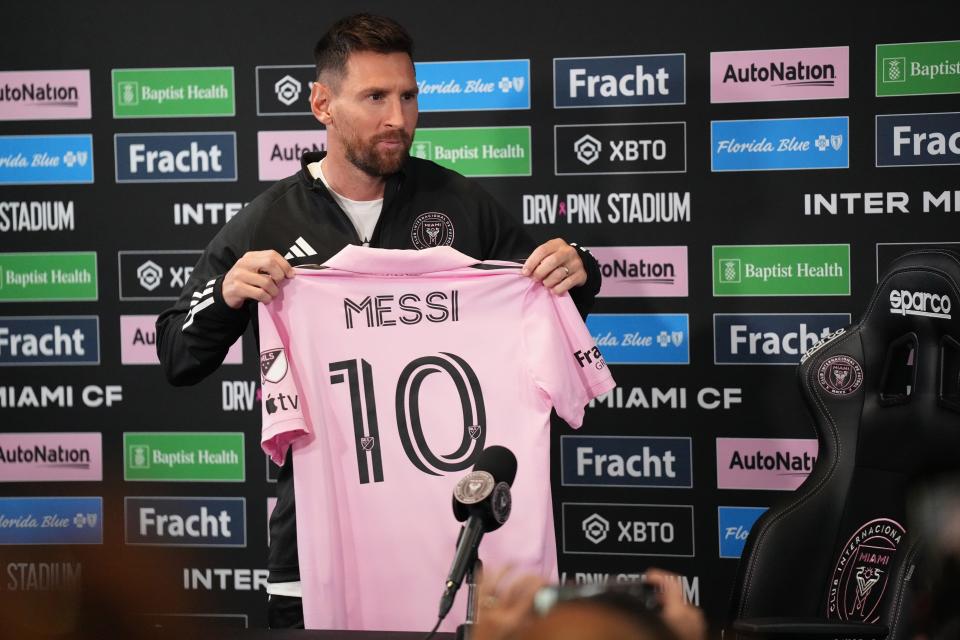 Lionel Messi of Inter Miami CF addresses the media Thursday, holding up his No. 10 jersey at the DRV PNK Stadium press conference room in Fort Lauderdale.