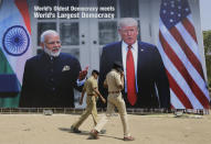 Indian policemen walks past a hoarding welcoming U.S President Donald Trump, at the airport ahead of his visit in Ahmedabad, India, Saturday, Feb. 22, 2020. To welcome Trump, who last year likened Modi to Elvis Presley for his crowd-pulling power at a joint rally the two leaders held in Houston, the Gujarat government has spent almost $14 million on ads blanketing the city that show them holding up their hands, flanked by the Indian and U.S. flags. (AP Photo/Ajit Solanki)