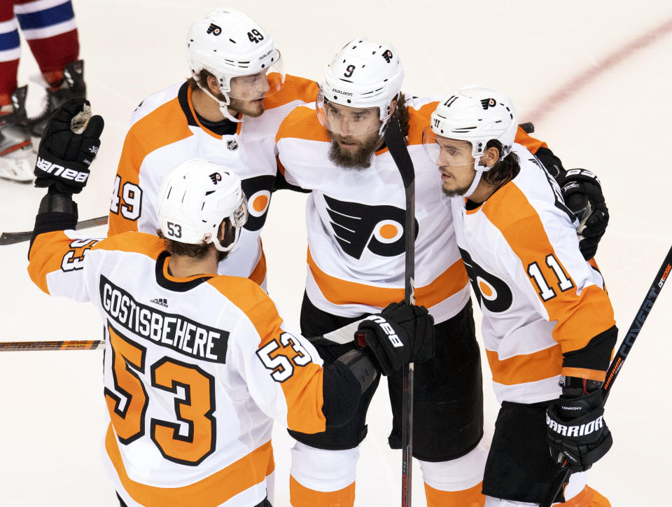 Philadelphia Flyers defenseman Shayne Gostisbehere (53), left wing Joel Farabee (49), defenseman Ivan Provorov (9) and right wing Travis Konecny (11) celebrate after Provorov scored their first goal against the Montreal Canadiens during the first period of an NHL Stanley Cup playoff hockey game in Toronto, Friday, Aug. 21, 2020. (Frank Gunn/The Canadian Press via AP)