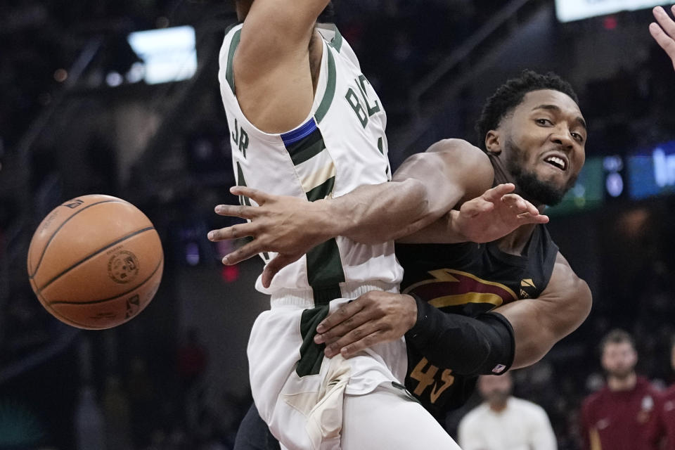 Cleveland Cavaliers guard Donovan Mitchell, right, passes the ball around Milwaukee Bucks guard Andre Jackson Jr. during the first half of an NBA basketball game Wednesday, Jan. 17, 2024, in Cleveland. (AP Photo/Sue Ogrocki)