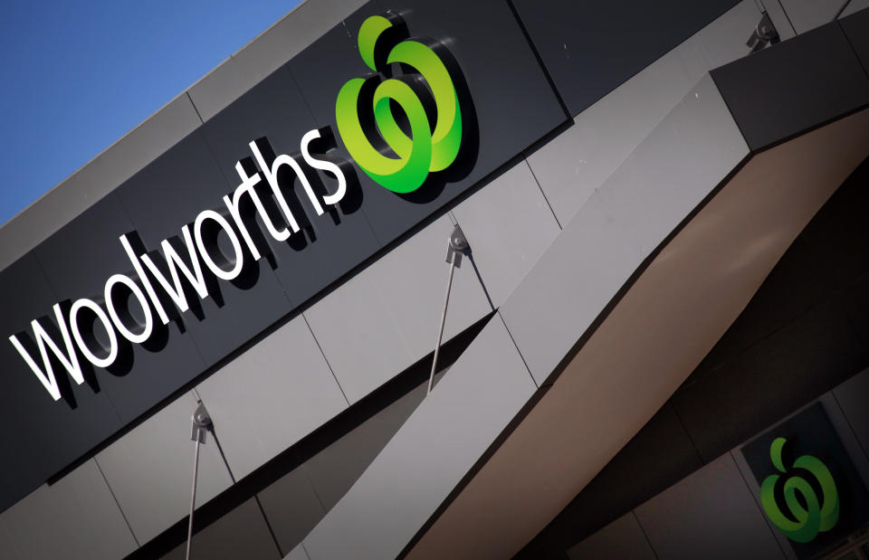 A Woolworths sign adorns the front of a supermarket store in Sydney. Photo taken on a diagonal showing the sky. Source: Reuters