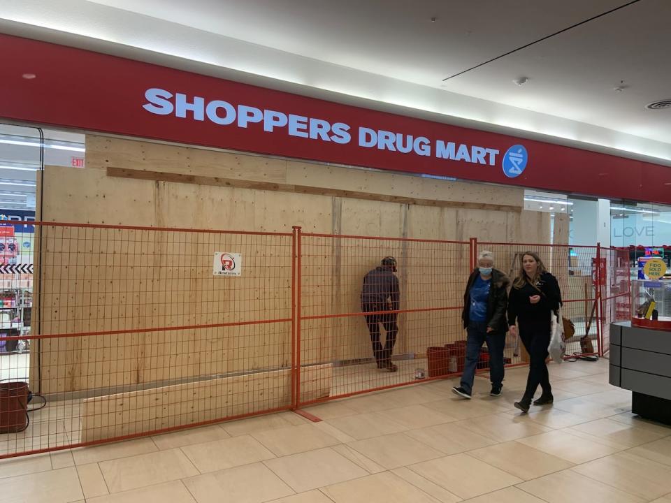 The front entrance of the Shoppers Drug Mart inside the Cornwall Centre in downtown Regina was boarded up on Saturday, Dec. 16, 2023, after police say a stolen taxi cab was driven through the mall. A 31-year-old woman was arrested following the incident, police said.