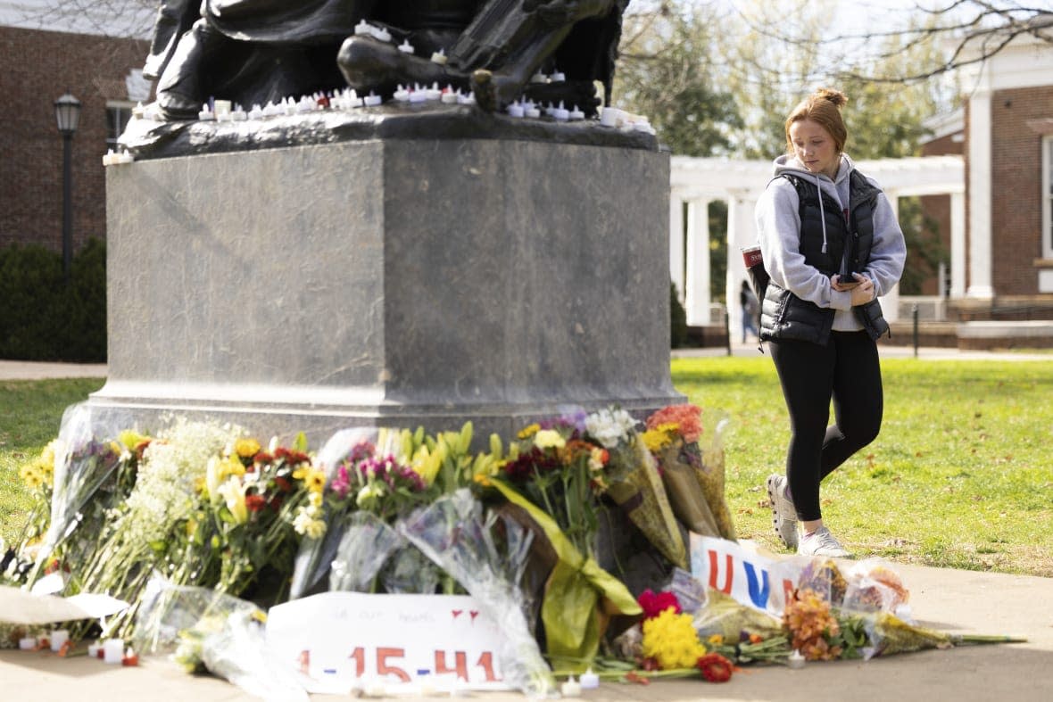 Meredith Flattum, a second year biology student at the University of Virginia, visits a memorial to three students who were killed in Charlottesville, Va., Wednesday, Nov. 16, 2022. (AP Photo/Mike Kropf)