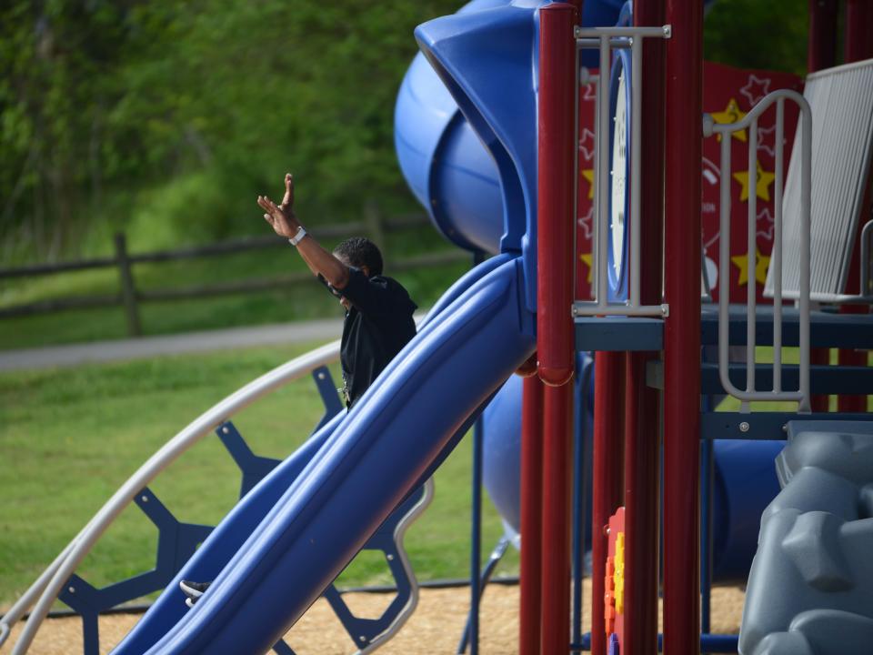 Director of South Jackson Community Center PeeWee Williamson rides a slide inside the newly renovated Paradise Park playground in Jackson, Tenn., on Monday, April 15, 2024. Paradise Park is one of three parks in the city to recieve new playgrounds.