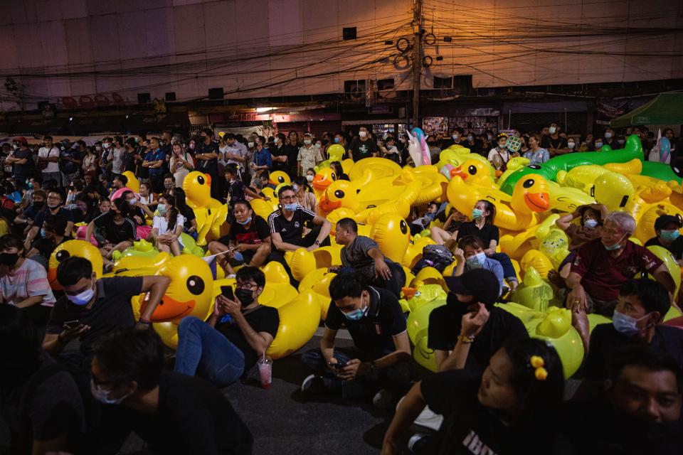 Protesters resting on inflatable ducks during a demonstration.