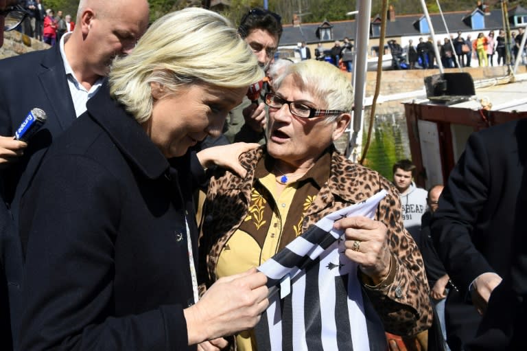 French presidential election candidate Marine Le Pen holds the flag of Brittany during her visit to the the harbour of Erquy on March 31, 2017