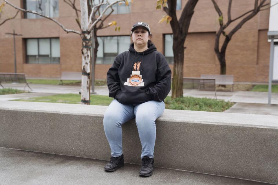 A woman sits on a concrete bench.