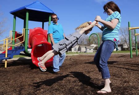 Andrea Smith and her husband Joe play with their daughter Norah at a playground in Winthrop Harbor, Illinois, May 9, 2014. REUTERS/Jim Young