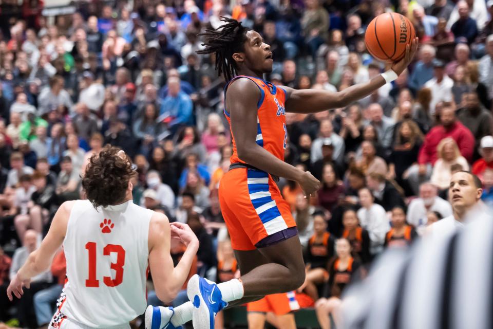 York High's Juelz Tucker flies past Central York's Ben Rill (13) as he scores on a layup during the YAIAA boys' basketball championship game at the York Tech Field House Feb. 16, 2023, in York Township. 