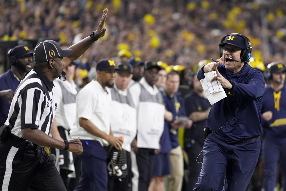 Michigan head coach Jim Harbaugh calls for a time out against Washington during the first half of the national championship NCAA College Football Playoff game Monday, Jan. 8, 2024, in Houston. (AP Photo/David J. Phillip)